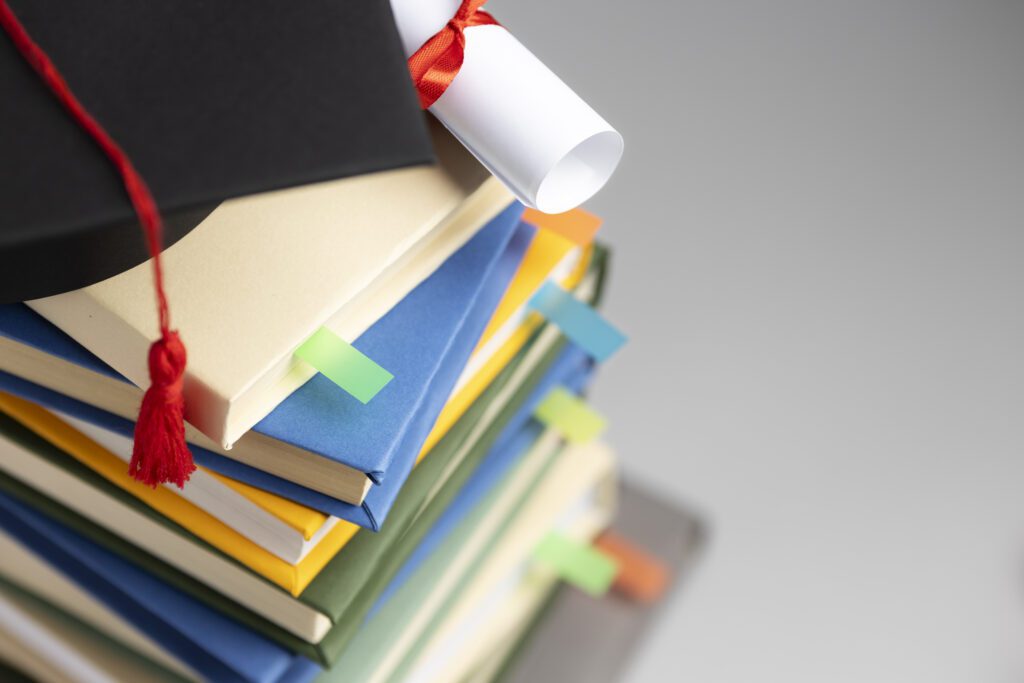 high angle stacked books graduation cap diploma education day