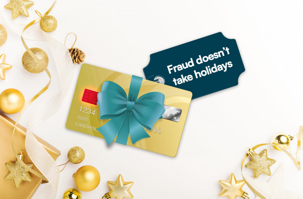 A credit card wrapped in a Christmas bow, with its chip glowing red. A tag caption reads, “Fraud doesn’t take holidays,” highlighting the rise of holiday scams during the festive season.