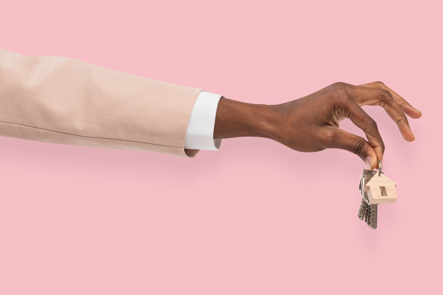 A hand holding house keys against a pink background, symbolizing secure and verified rental transactions.