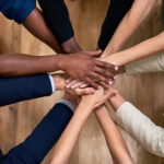 Several hands stacked together to symbolize trust, unity, and strong workplace relationships.